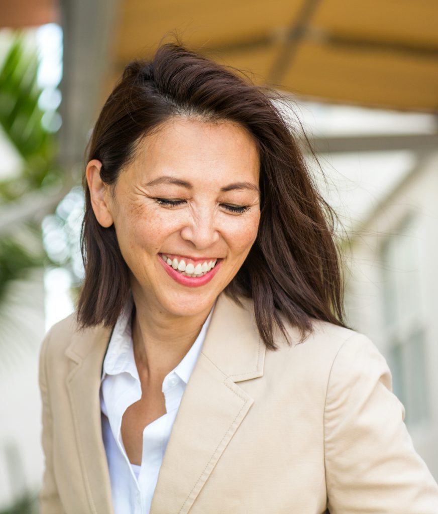 Smiling woman in a blazer looking down